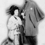 Onoe Fujaku VIII left as Okaru and Morita Kanya XIII as Oboshi Yuranosuke in 1910 production of Kanadehon Chushingura Act VII. Image uploaded by Shirabyoshi Hanako [Public Domain], via Wikimedia Commons. Original author unknown.