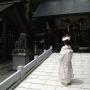 A newly married bride in traditional wedding dress stands outside the shrine. Photo by JL, (c) ASC
