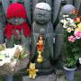 A row of ojizo-san statues watch over children at a temple. Photo by JL, (c) ASC